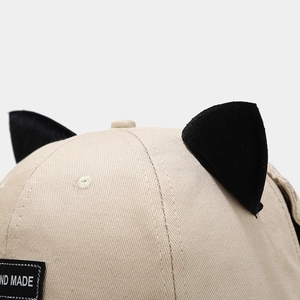 Detail of canvas baseball cap with cat ear decor and handmade woven label on the side
