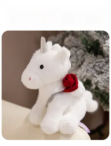 Detail of white unicorn plush with silver horn and red rose decoration for gift giving