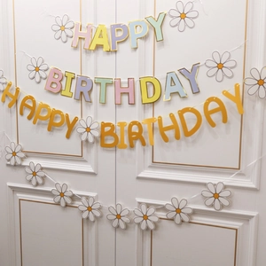 Daisy birthday banner with pastel letters and paper flowers for kids party decoration backdrop.