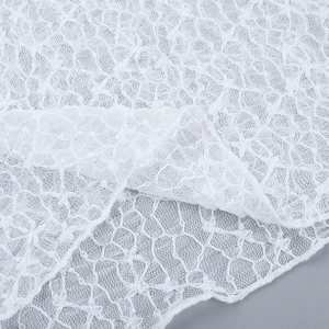 Primer plano de tela de encaje blanco transparente con delicados patrones florales