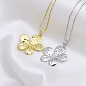 Elegant gold and silver flower pendant necklaces on white silk background with box chains