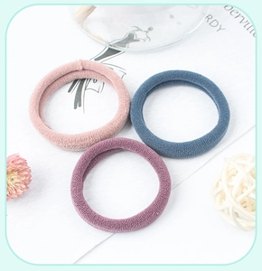 Three seamless knit hair ties in pastel pink, purple, and blue colors for ponytails