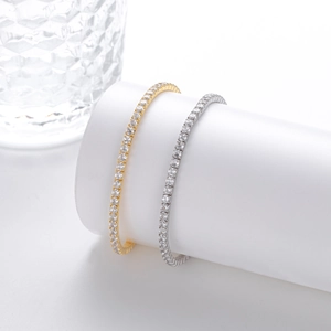 Close-up of gold and silver tennis bracelets with four-prong set sparkling round zircons