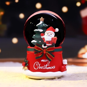Christmas snow globe with Santa and tree on a red base with a Merry Christmas bow