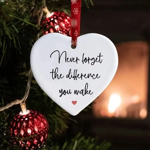 Ceramic heart ornament with inspirational quote hanging on a festive Christmas tree