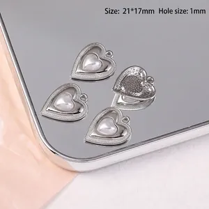 Détail de quatre breloques cœur avec perles sur plateau miroir, taille 21x17mm