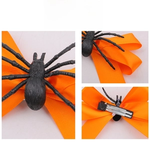 Détail de la pince à cheveux araignée d'Halloween avec un nœud en satin orange vif