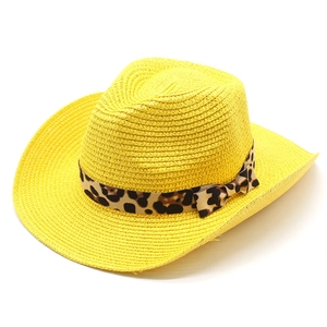 Detail of yellow straw cowboy hat featuring a leopard print band and side bow decoration