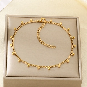 Detail of gold beaded anklet with lobster clasp and extension chain on jewelry box