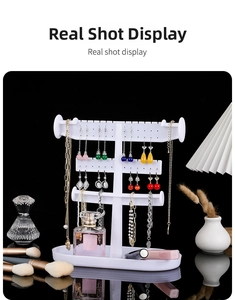 White multi-tier plastic jewelry organizer detail with earring holes and storage tray