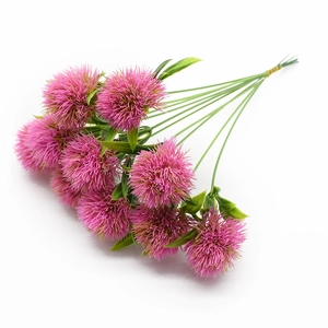 Détail d'un bouquet de pissenlits artificiels roses avec tiges vertes sur fond blanc