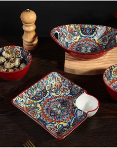 Close-up of bohemian ceramic dinnerware set featuring colorful floral patterns on a dark wood table