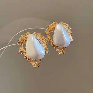 Boucles d'oreilles triangles dorés irréguliers avec perle et texture vintage de lave