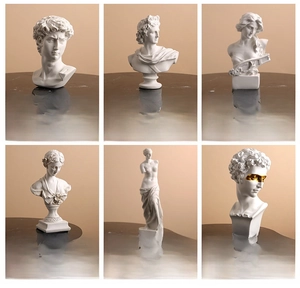 Classical Greek statues including David with gold eye mask and Venus resin sculptures