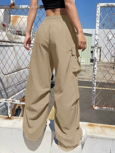 Detail of khaki cargo pants with side pockets and loose fit wide-leg design for women