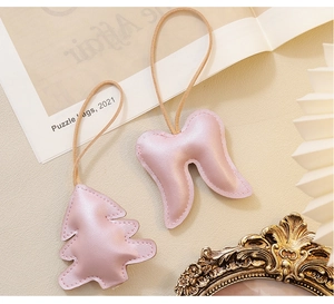 Close-up of pink metallic leather Christmas tree and angel wing ornaments with fine stitching