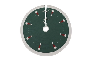 Détail du tapis de sapin de Noël tricoté vert avec motifs bonnets rouges et nœuds blancs