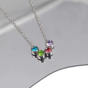 Collier en argent avec pendentif en zircon arc-en-ciel sur une surface réfléchissante