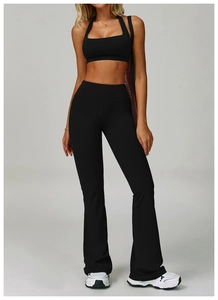 Detail of high-waisted black flared yoga pants with matching sports crop top set