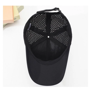 Detailed internal view of black quick-dry baseball cap showing laser-cut breathability holes