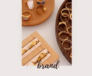 Detail of vintage 18K gold-plated rings with freshwater pearls on a wooden tray