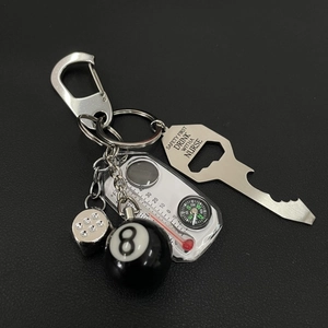 Metal dice and billiard 8 keychain combo with opener and compass on black background