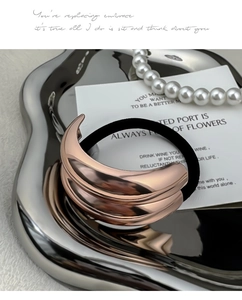 Detail of rose gold layered alloy hair ring with black elastic band on mirror tray