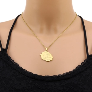 Close-up of golden La Réunion island map pendant necklace with engraved place names