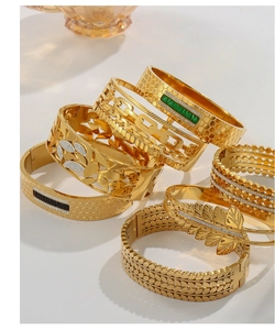 Detailed view of layered gold-plated titanium steel bracelets with zircon inlays and hollow designs