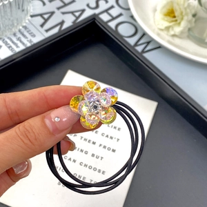 Detailed macro view of a 3D double-layered crystal flower hair tie on an elastic band