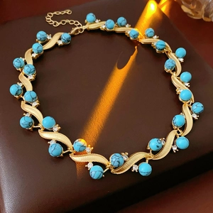 Vintage gold necklace featuring geometric turquoise beads and crystal accents