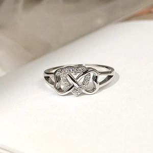 Macro shot of micro-pave heart and infinity symbol silver ring with white gems