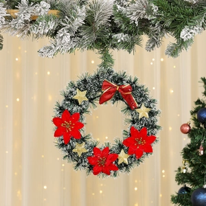Detailed view of Christmas wreath with red poinsettias, golden stars and snowy pine needles