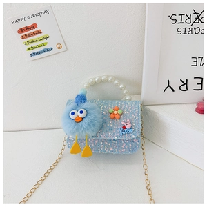 Detail of light blue sequined girl's bag with pearl handle and plush doll pendant