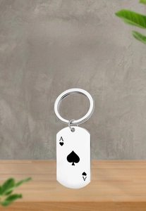 Detailed macro of stainless steel ace of spades dog tag keychain with black oil drip finish
