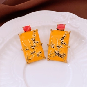 Macro detail of vintage square floral drop earrings with yellow enamel on a relief plate
