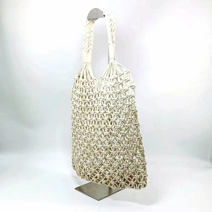 Detail of white handmade woven tote bag with intricate knot texture and thick handle