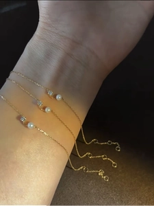 Detailed view of three 18K gold plated S925 silver bracelets with pearls and zircons