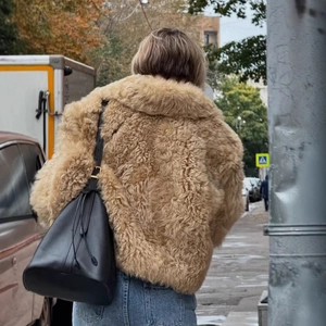 Vue de dos d'une veste décontractée en peau de mouton kaki avec sac bandoulière en cuir noir