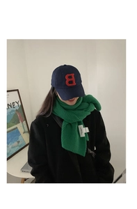 Close-up of bright green chunky knit scarf paired with a navy blue letter B cap
