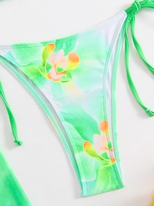 Detailed view of green floral bikini bottom with fine white stitching and side ties