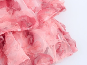 Detalle de tela de malla rosa por capas con pétalos 3D y costuras precisas
