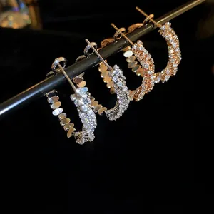 Sparkling zircon paved C-shaped hoop earrings in gold and silver finishes for women