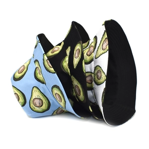 Trois bobs à imprimé avocat en bleu, noir et blanc présentés sur un fond blanc épuré