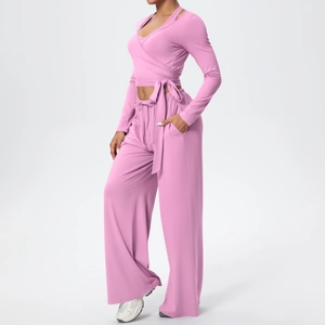 Détail de l'ensemble de yoga mauve avec haut cache-cœur et pantalon large taille haute