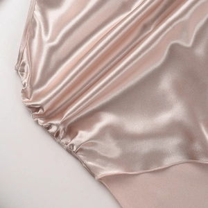 Détail du luxueux tissu en satin champagne avec un drapé élégant et une texture soyeuse
