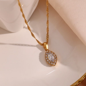 Golden necklace featuring a marquise-cut zircon leaf pendant with halo setting on white satin