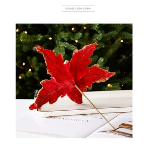 Détail d'un poinsettia rouge velours aux bords pailletés dorés pour sapin de Noël