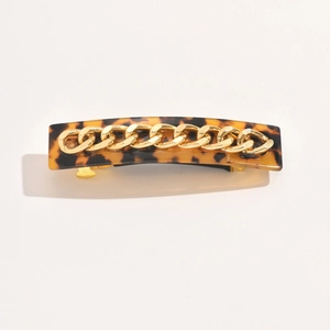 Detail of amber tortoiseshell acetate hair clip with a stylish gold metal chain accent
