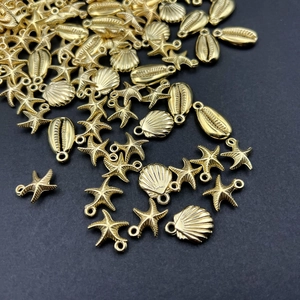 Close-up of gold-plated starfish and seashell CCB charms for DIY jewelry making